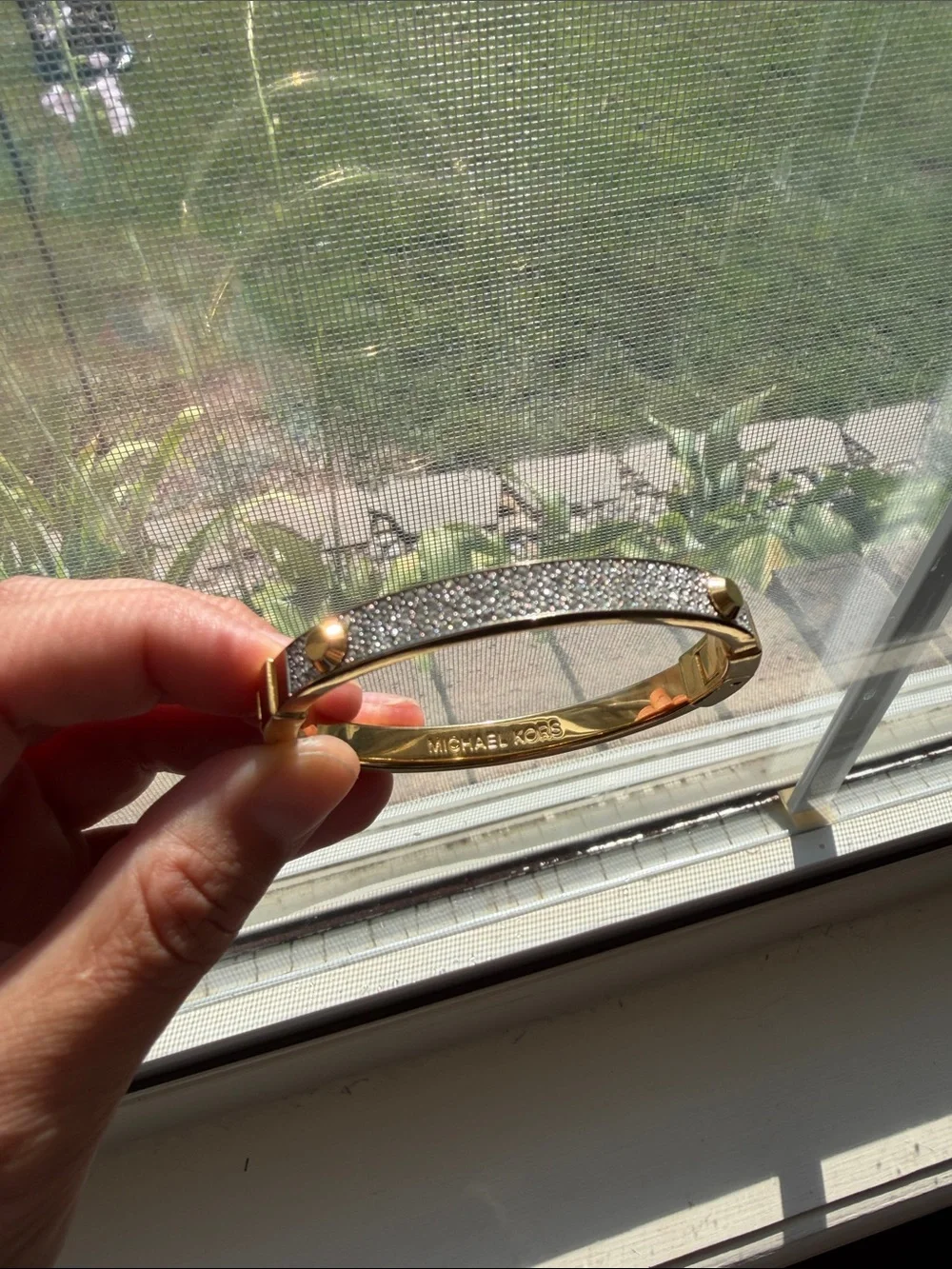 Michael Kors gold-tone hinge bangle featuring a center row of pave-set crystals